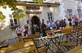 Kellerstüberl Stift Lilienfeld, © zVg Menschen vor einem traditionellen Gasthaus mit Biergarten.