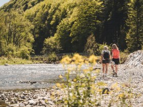 Zwei Frauen machen eine Pause am Wasser.