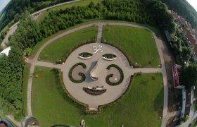 Luftaufnahme eines Gartens mit Gesichtsmuster aus Pflanzen und Wegen.